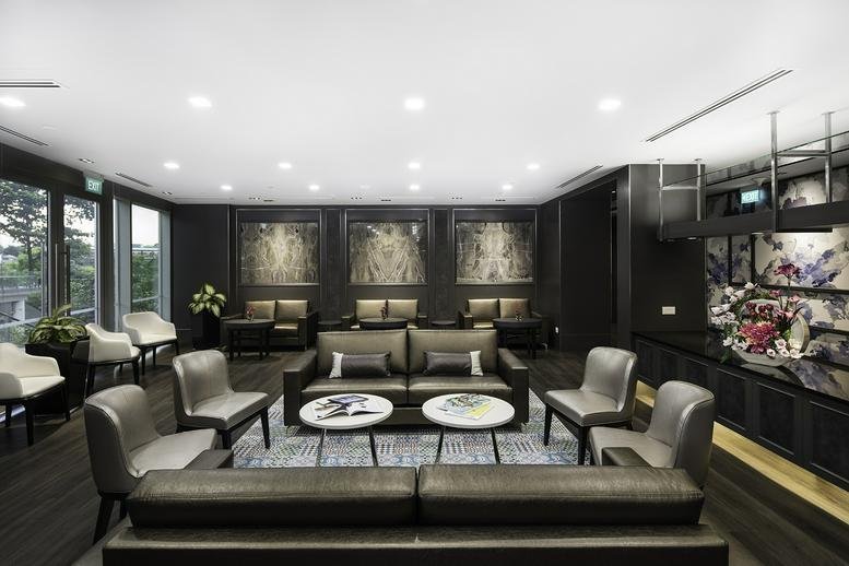 Sophisticated communal lounge with leather seating, circular coffee tables, and dark wood accents.