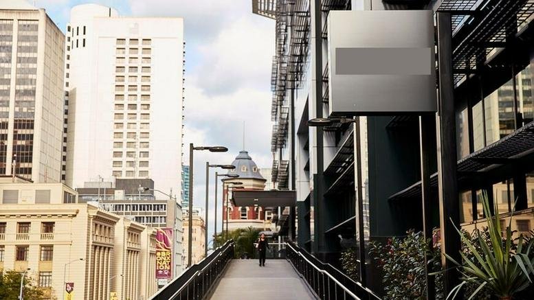 Elevated walkway at 310 Edward Street leading toward a modern building entrance in the city.