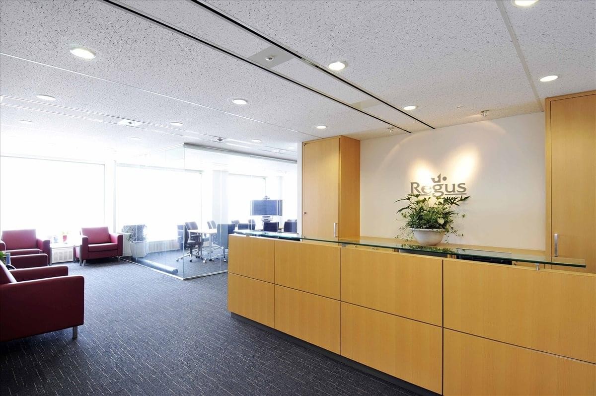 Spacious wood-paneled reception area at Osaka Kokusai Building with a floral arrangement and lounge seating.