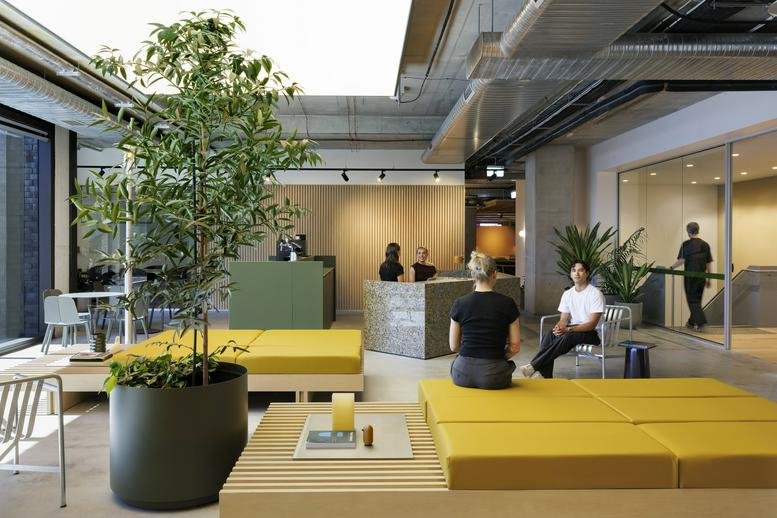 Spacious reception and lounge at The Commons Richmond, 33 Cremorne Street, featuring yellow seating and indoor plants.