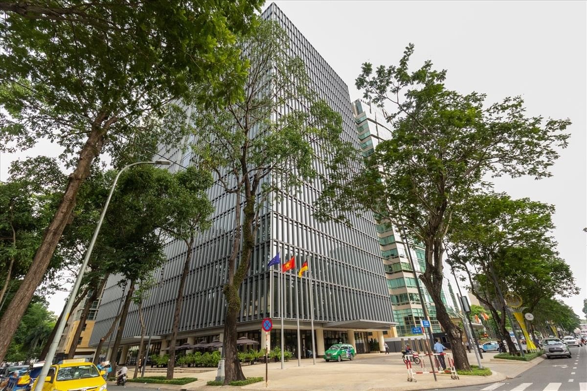Exterior view of the glass-facade Deutsches Haus building and surrounding trees.