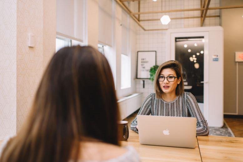 Modern workspace at WeWork Wan Chai, Hong Kong featuring glass-walled pods and vibrant common areas.