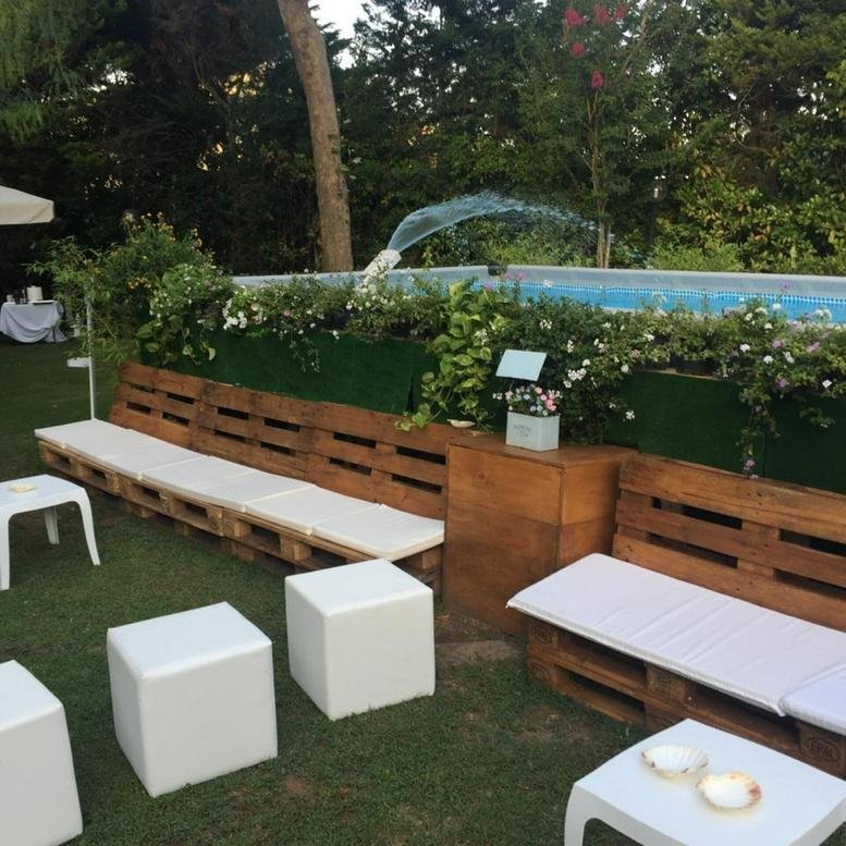 Outdoor lounge area at 373 Gangnam-daero with pallet seating, white cube stools, and a pool in the background.