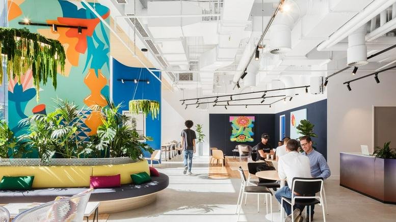 Spacious communal lounge at 383 George Street, Sydney, New South Wales with vibrant murals and indoor plants.