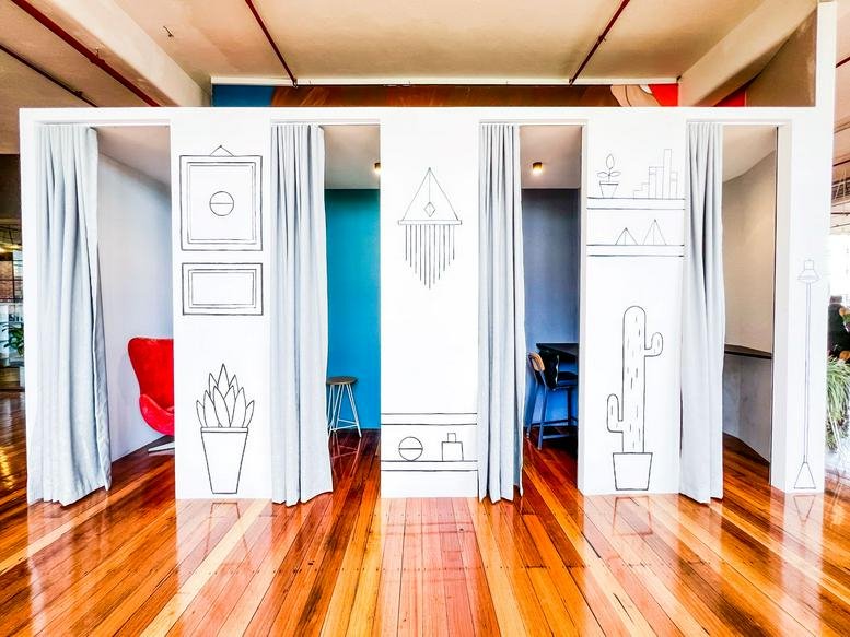 Spacious communal area at 41-43 Stewart Street featuring private phone booths with hand-drawn illustrations.