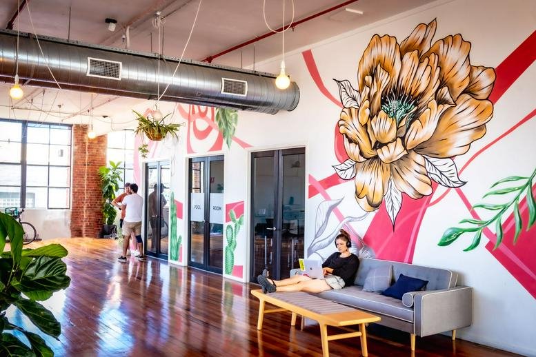 Spacious communal area at 41-43 Stewart Street, Richmond featuring a large floral mural and lounge seating.