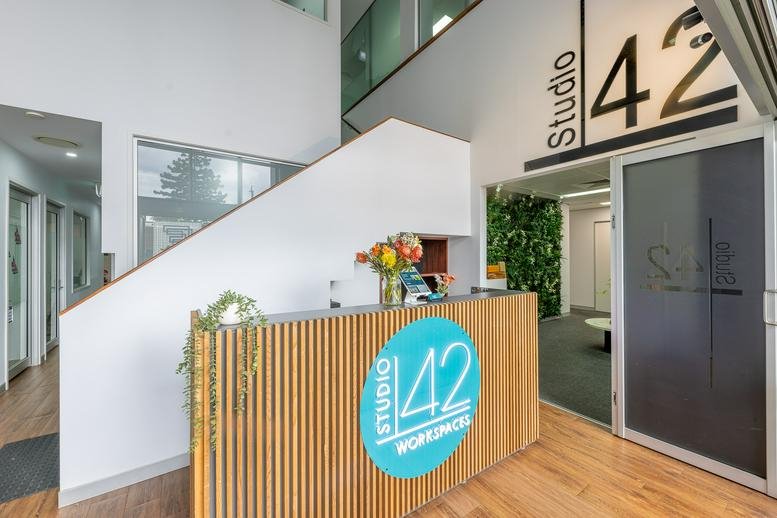 Modern reception area with a wood-slat desk and Studio 42 signage at 42 Manilla Street.