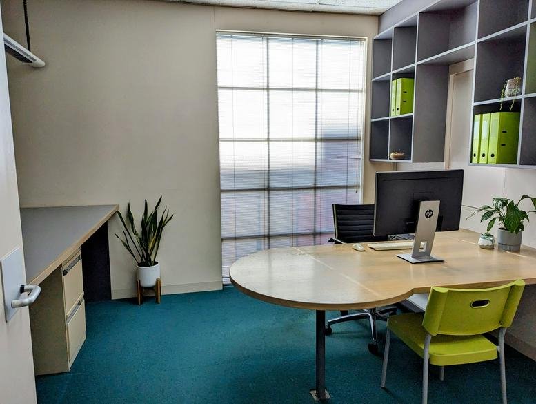 Private office at 424 Burke Road (1st Floor) with a wooden desk, lime green chair, and natural light.