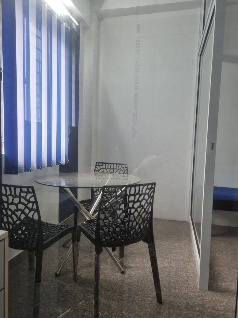 Meeting area with glass table and black patterned chairs at 43 KRG Nagar Main Street, Coimbatore, India.