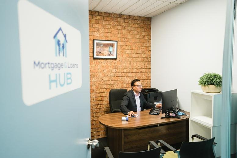 Signage for Westend Business Hub on a light blue door leading to a private office with a brick feature wall.