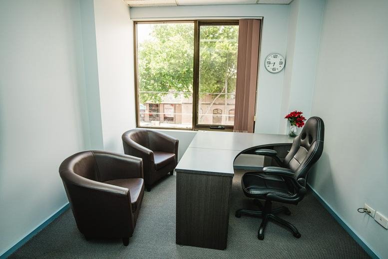 Modern office interior at Westend Business Hub with stylish armchairs and window views.