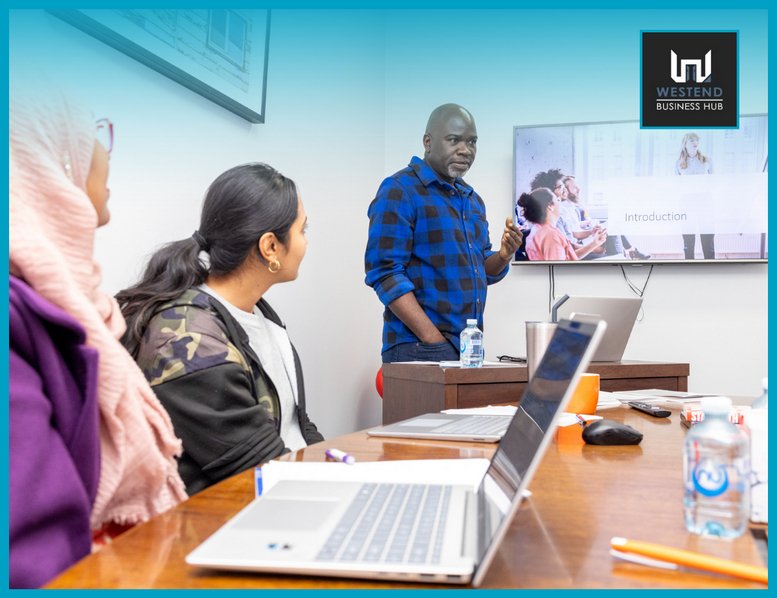 Team meeting at Westend Business Hub with a presenter and digital screen.