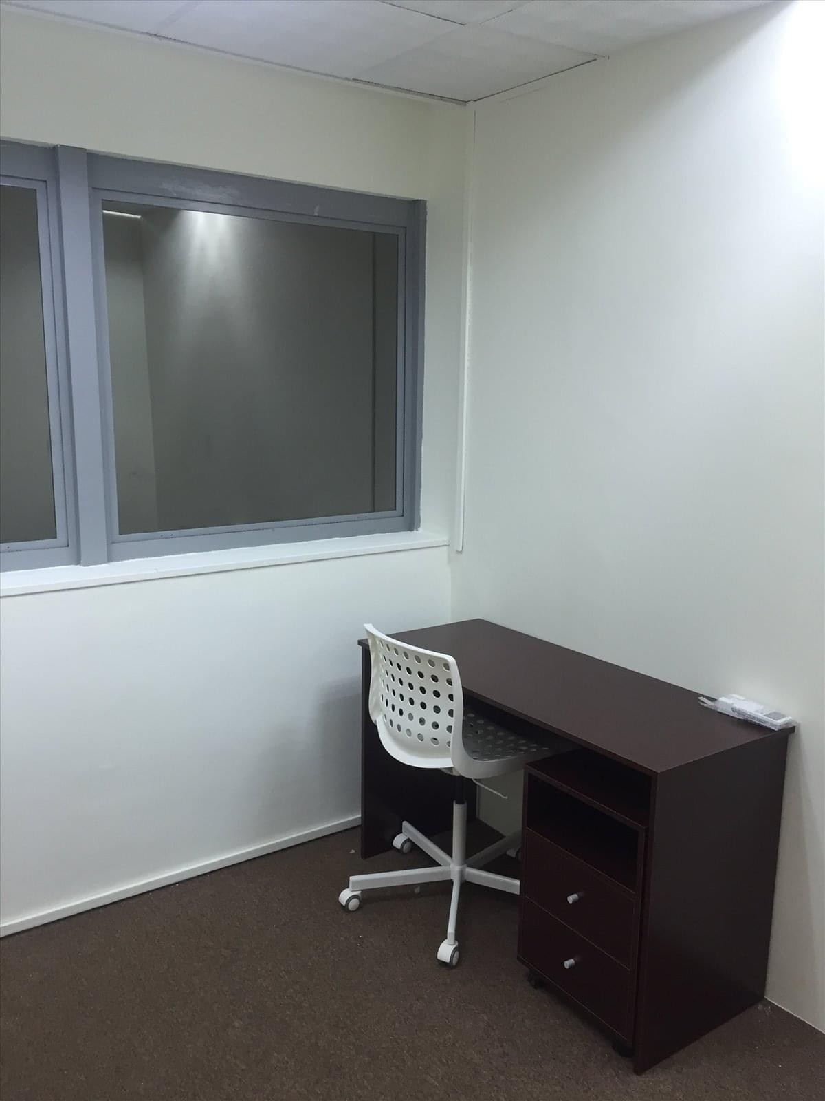 Private office suite at 452 North Bridge Road featuring a dark wood desk and white mesh task chair.