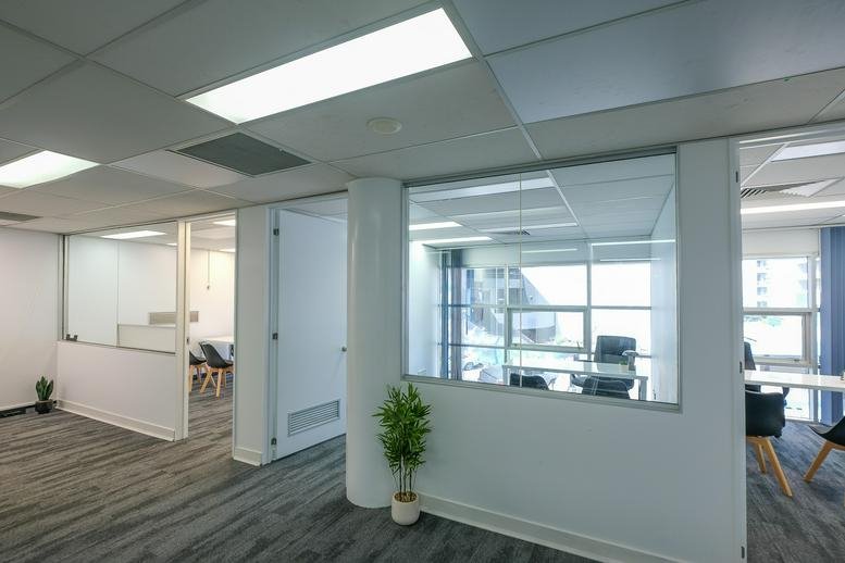 View of the Business Hub Spring Hill workspace featuring modern glass-walled office suites.