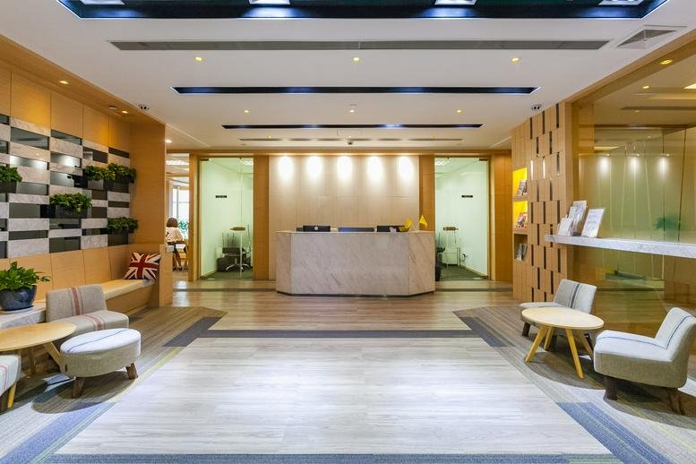 Brightly lit reception area with a stone front desk and comfortable visitor seating.