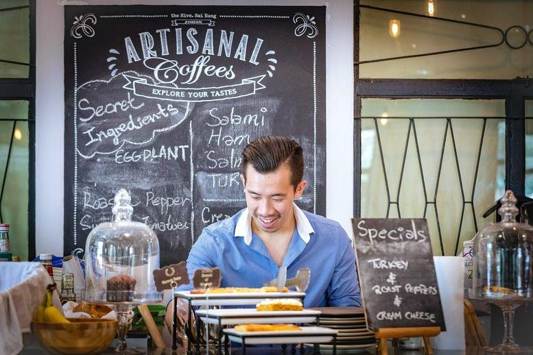 Cafe counter at 5 Tai Mong Tsai Road with a barista and artisanal coffee chalkboard menu.