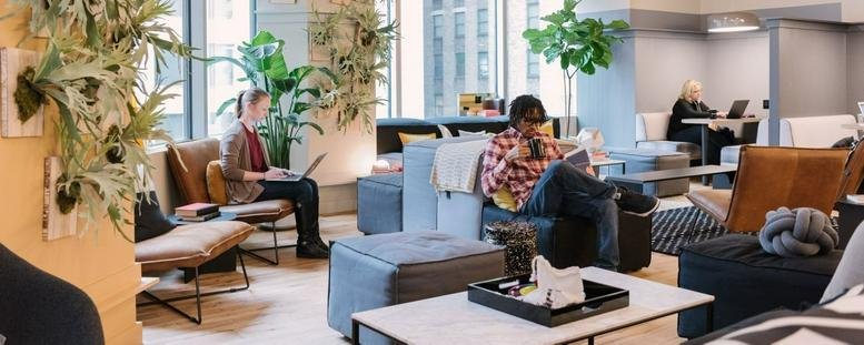 Spacious communal lounge with diverse seating, indoor plants, and natural light at Suntec City Tower 5.