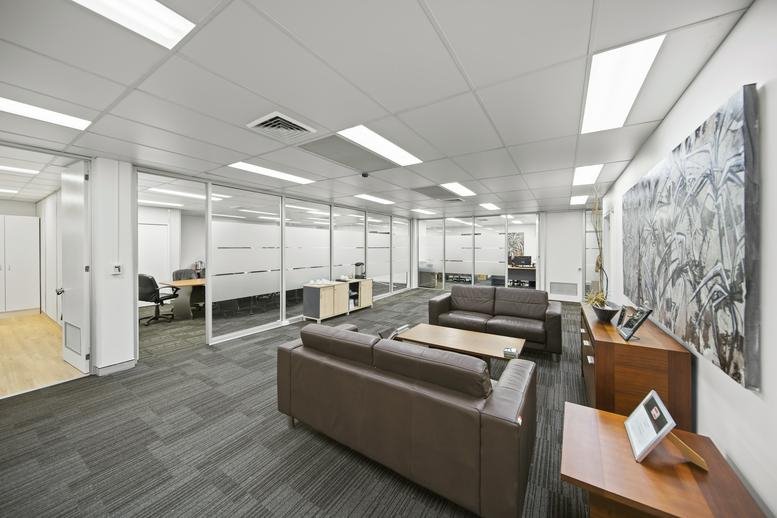 Spacious communal lounge at Sturt Business Centre with leather sofas and large abstract wall art.