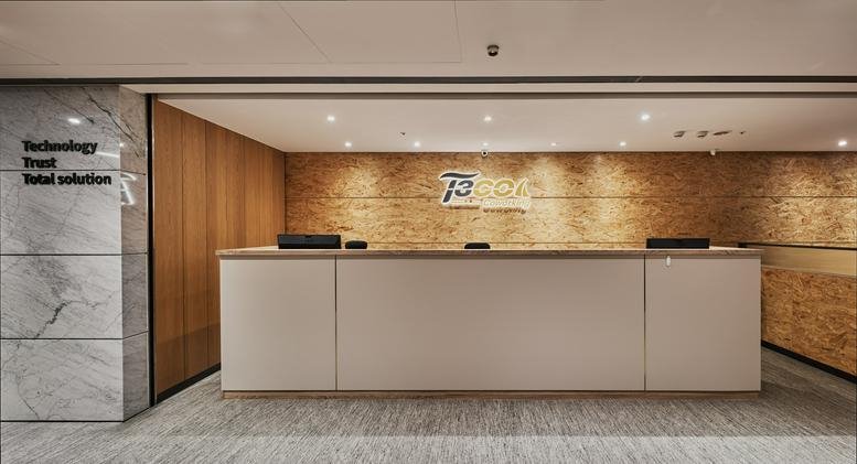 The sleek white reception desk at T3CO韻驊共享辦公 with a light wood accent wall.