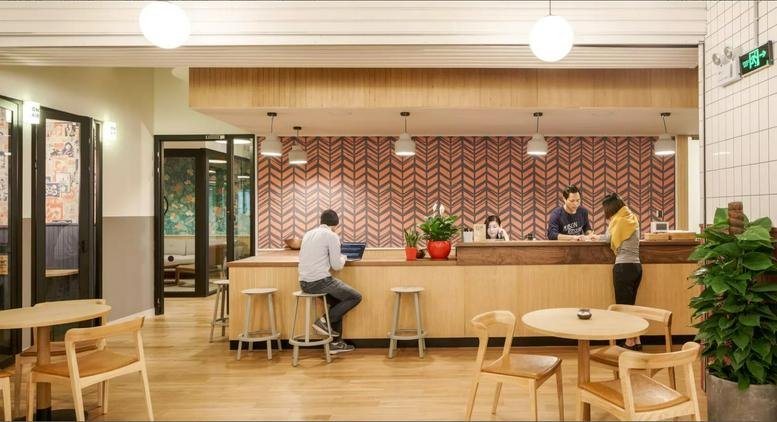 Reception desk at 588 Yan'an East Road Huangpu District featuring a patterned feature wall and wooden bar seating.