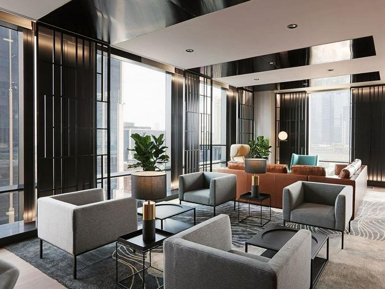 Spacious communal lounge at 600, Zhongshan No. 2 Road, Shanghai with grey armchairs and city views.