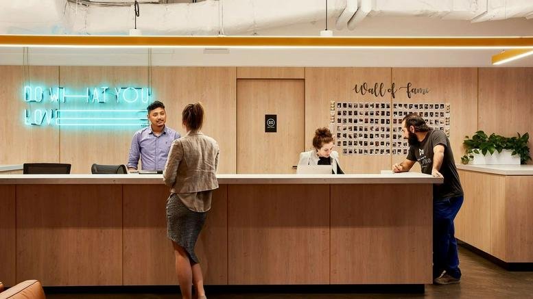 Wood-paneled reception area at Level 9-12, 64 York Street, Sydney, New South Wales with a neon sign and front desk.