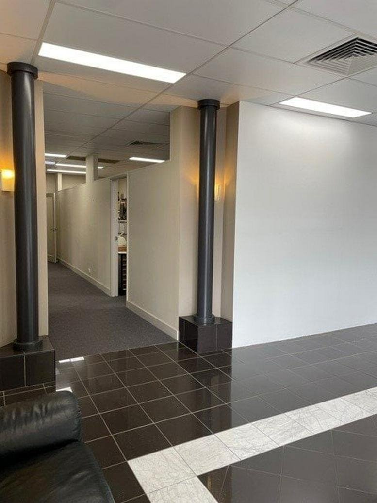Spacious lobby at 671 - 677 Hunter Street, Newcastle, Australia featuring dark tile floors and architectural columns.