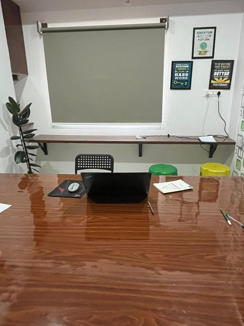 Meeting room at SMS Complex, 7 Basapura Main Road with a large wooden table and laptop.