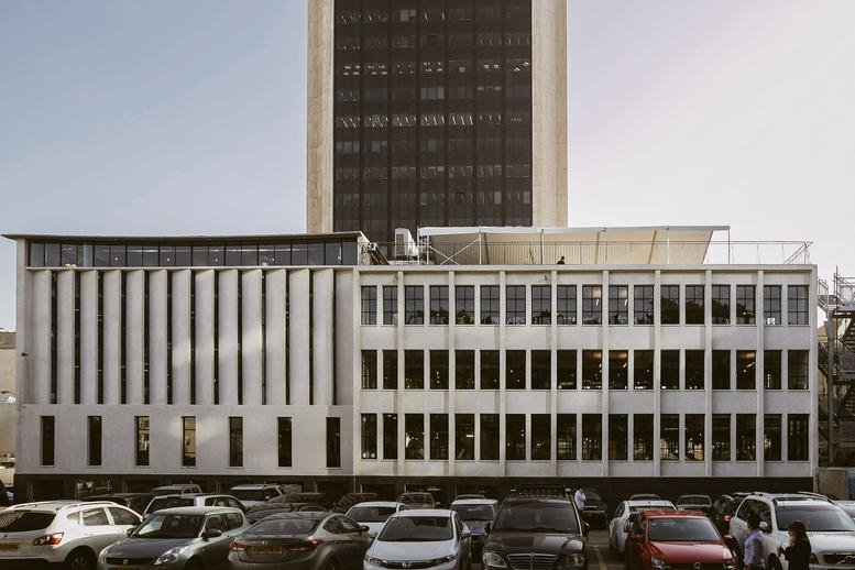 Exterior view of the multi-story white building with a gridded window facade at 7 Dubnov, Tel Aviv, Israel.