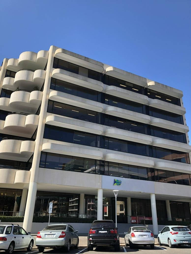 Wide exterior view of 70 Hindmarsh Square showcasing the building architecture and street-level parking.