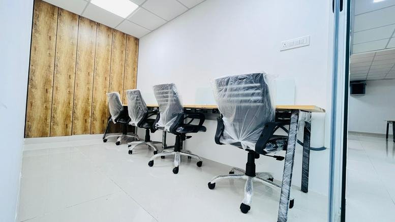 Row of ergonomic desk chairs with protective coverings in a minimalist private office.
