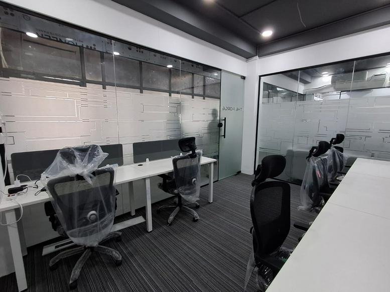 Spacious interior at Universe Coworks, 2nd Floor, 74A Salai Road, Tiruchirappalli with glass partitions.