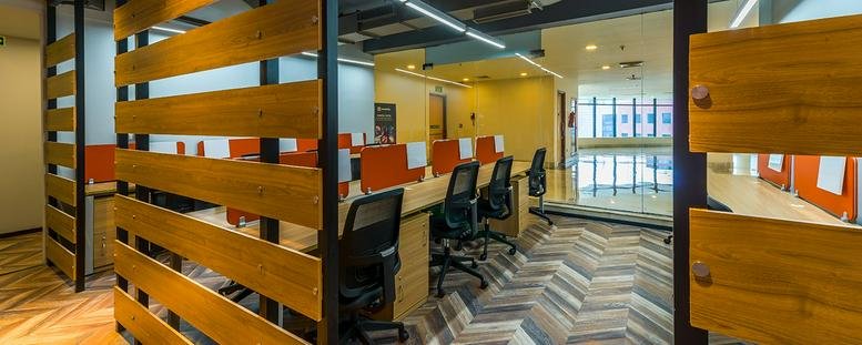 Open-plan office at 8/1A Sir William Jones Sarani with wooden slat partitions and ergonomic chairs.