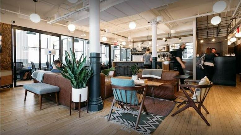 Spacious coworking lounge at 8 Cross Street, Downtown District, Singapore with leather sofas and large windows.