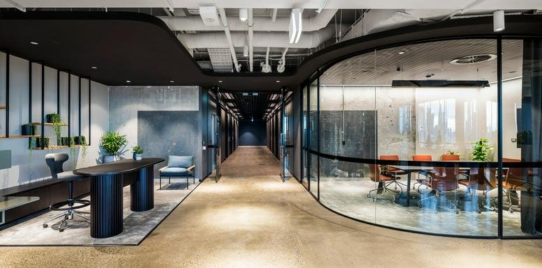 Spacious reception area at 8 Exhibition Street with a curved glass boardroom and modern workstation.