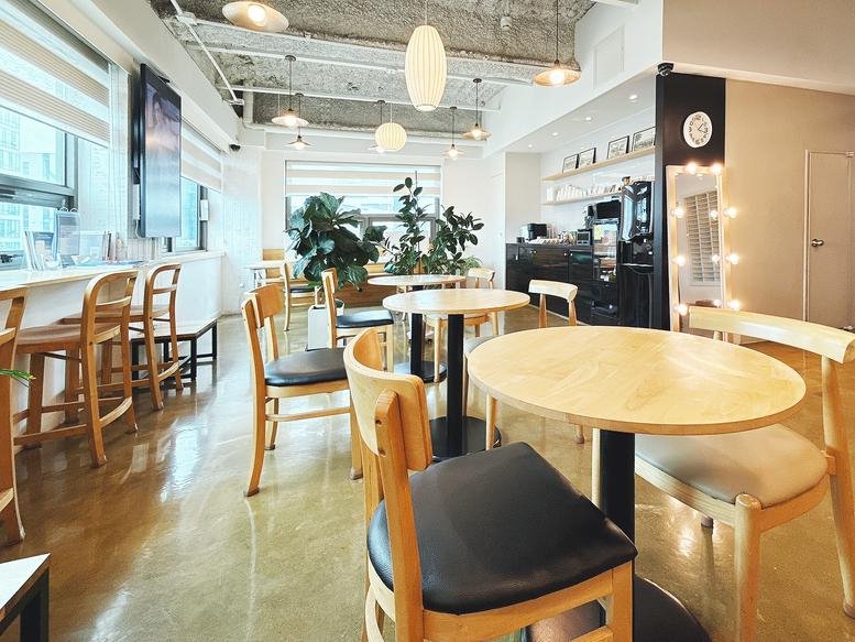 Wide-angle view of Aimhigh Tower featuring a stylish communal area with warm wood finishes.