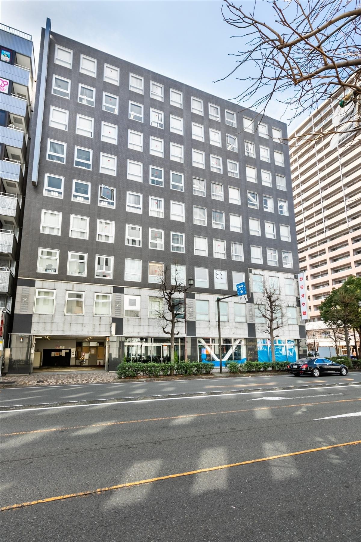 Exterior view of the 8F Yokohama Onoecho Building showing its modern dark gray and glass facade.