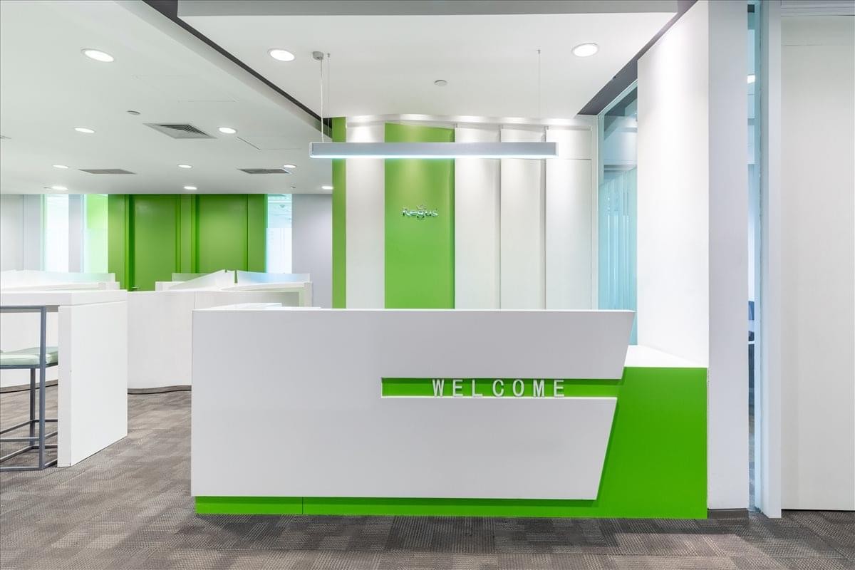 Bright, modern reception area of Xiwang Tower with vibrant green accents and a white desk.