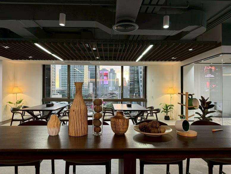Spacious communal lounge at 90/42 North Sathon Road featuring city views, wooden tables, and decorative vases.