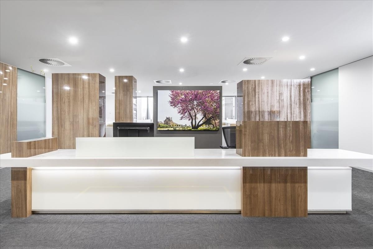 Professional reception desk featuring white and timber finishes with a floral wall mural.