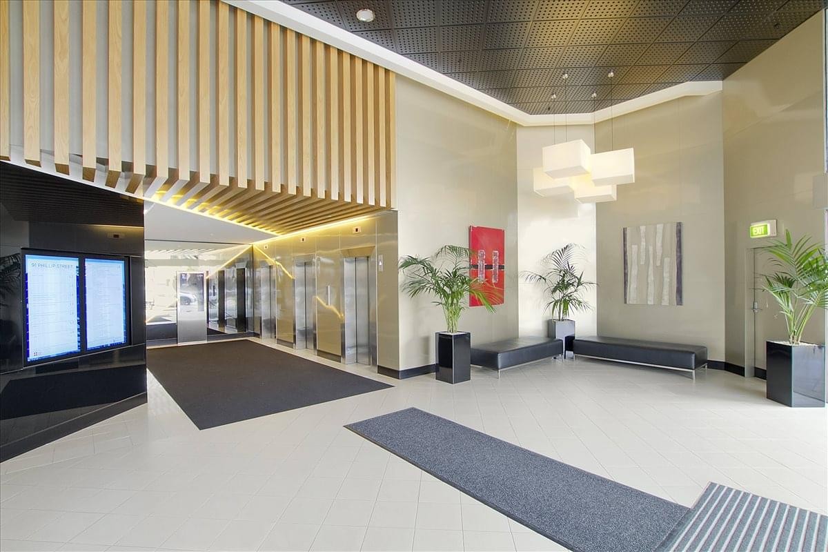 Modern lobby at 91 Phillip Street featuring a slatted wooden ceiling and sleek elevators.