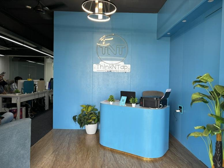 Bright blue reception area at Shekhar Central, 919, 9th Floor, AB Road, Indore, India with curved desk and plants.