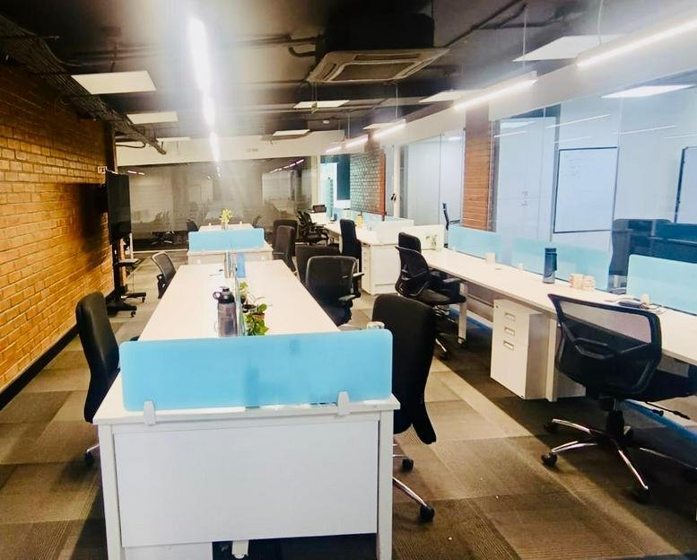 Spacious open-plan workspace at 9th Cross Road, JP Nagar 2nd Phase, Bengaluru, India with white desks and blue dividers.