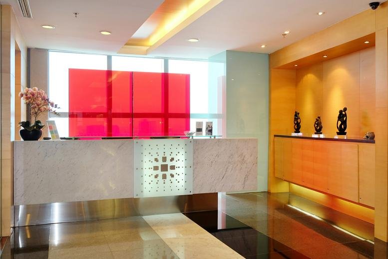 Modern reception desk with a marble-patterned front and a vibrant red feature wall.
