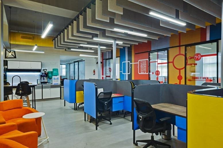 Spacious open-plan workspace at A-16, 1st Floor, Aruna Asaf Ali Marg with colorful cubicles and modern lighting.