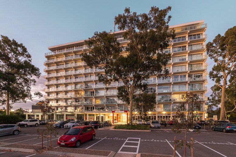 Exterior view of the multi-story The Watson, 33 Warwick Street building and front parking area.