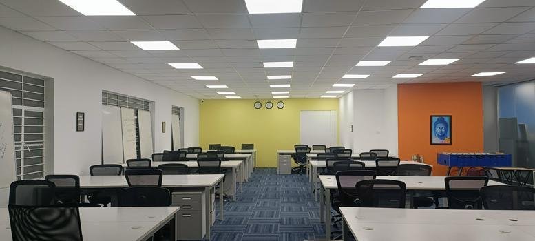 Spacious open-plan workspace at Aishwarya Crystal Layout Road, Singasandra, Bengaluru, India with orange and yellow walls.