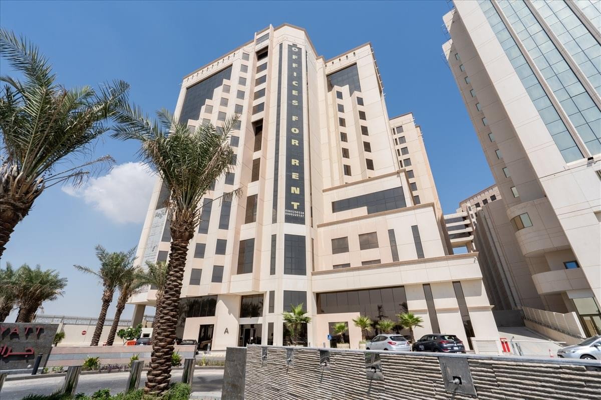 Exterior view of the Al Rashed tower (A) featuring modern multi-level architecture and palm trees.