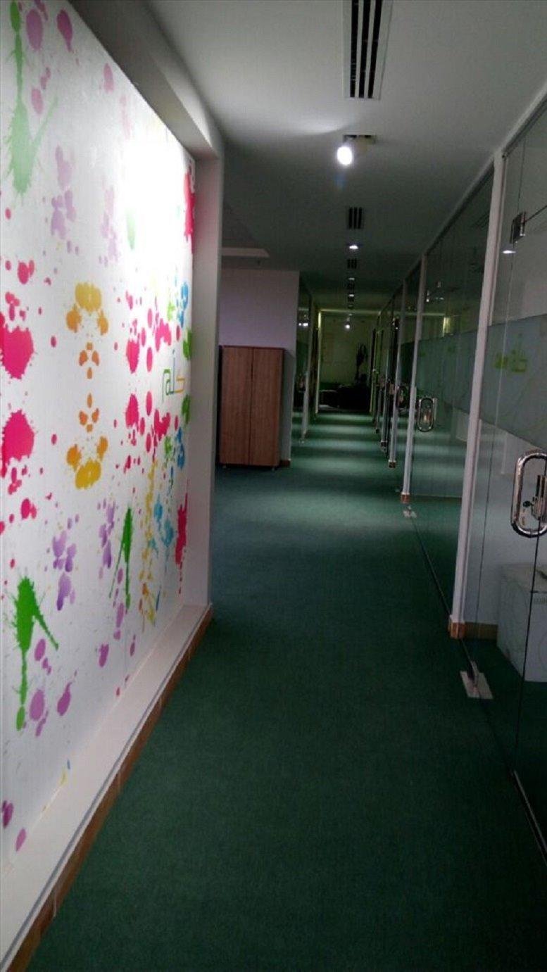 A hallway at Al Sahafa, King Abdul Aziz Road featuring a vibrant paint-splatter feature wall and green carpeting.
