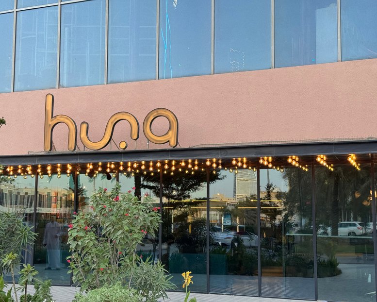 Exterior view of the Al Takhassousi building entrance with glowing gold signage.